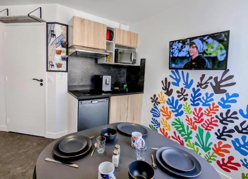 a kitchen with a table with plates on it at Résidence M - LAVALOC in Laval
