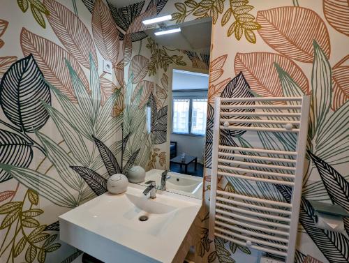 a bathroom with a sink and a mirror at Résidence M - LAVALOC in Laval