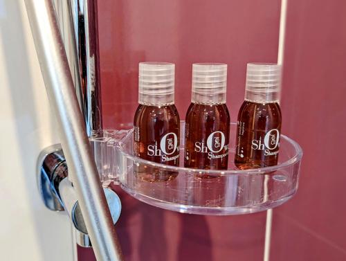 three bottles of syrup sitting on a shelf in a refrigerator at Résidence M - LAVALOC in Laval