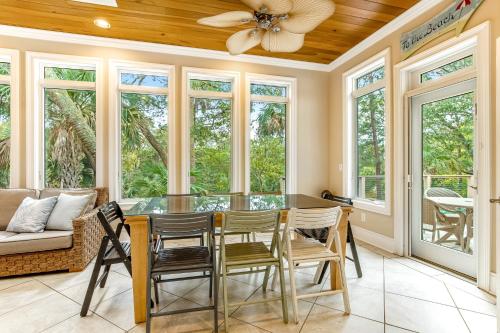 a dining room with a ceiling fan and windows at Bufflehead 3 in Kiawah Island