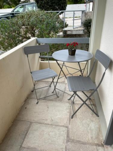 een tafel en 2 stoelen op een balkon bij Sophia's studio in Saronida