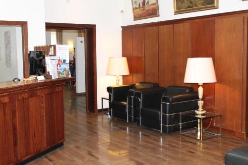 a waiting room with two chairs and a lamp at Hotel Weidenhof in Düsseldorf