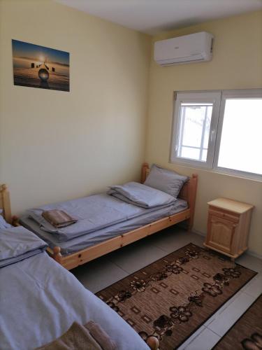 a bedroom with two twin beds and a window at Къща за гости Релиса in Razgrad