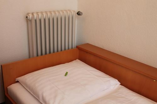 a small bed in a room with a radiator at Hotel Weidenhof in Düsseldorf