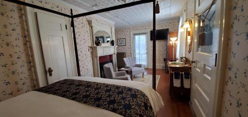 a bedroom with a bed and a desk and a fireplace at Blackberry Inn in Camden
