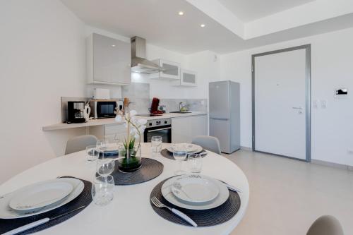 une salle à manger blanche avec une table et des chaises blanches dans l'établissement La Cantonade - Nice T2 with garage for 4 people near Beach, à Annecy