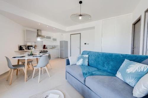 uma sala de estar com um sofá azul e uma mesa em La Cantonade - Nice T2 with garage for 4 people near Beach em Annecy