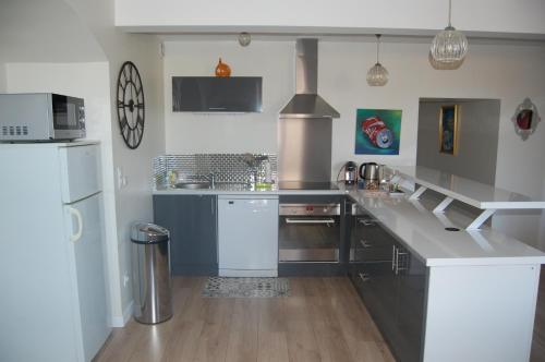a kitchen with a large counter and a refrigerator at La Maison de Marie in Charnay-lès-Mâcon
