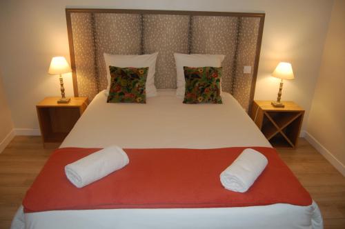 une chambre avec un grand lit blanc avec deux lampes dans l'établissement La Maison de Marie, à Charnay-lès-Mâcon