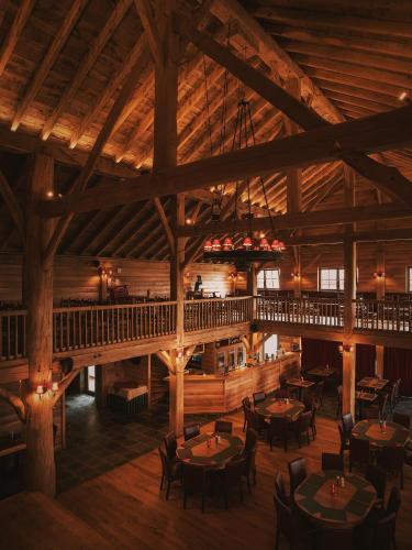 a restaurant with tables and chairs in a wooden building at Country Lodge Hotel Moriaanshoofd in Oudenaarde