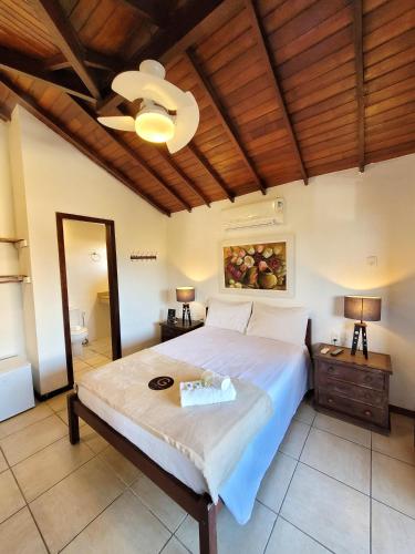 a bedroom with a large bed and a wooden ceiling at Pousada Centro Class in Búzios