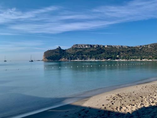 a view of a beach with a mountain in the background at Hotel Poetto in Cagliari
