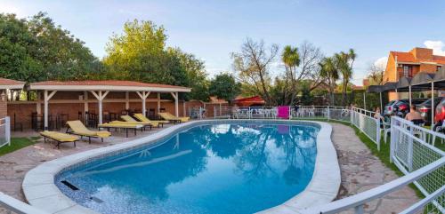 a pool at a resort with tables and chairs at Hotel Valle Del Sol in Merlo