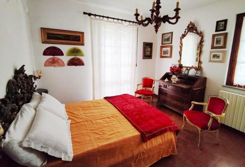 a bedroom with a bed and a desk and chairs at Grazioso rustico Toscano in Luciana