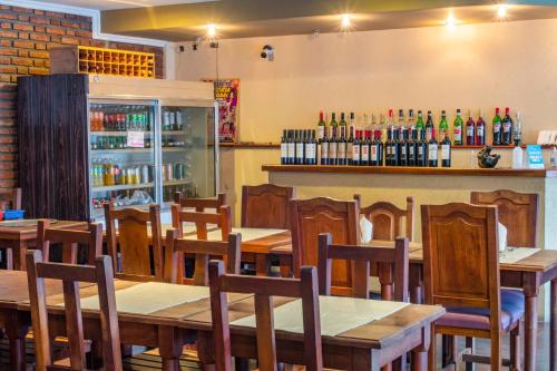 a restaurant with wooden tables and chairs and a bar at Hotel Valle Del Sol in Merlo