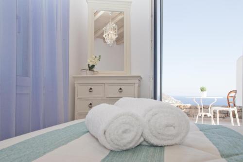 a white bed sitting under a window in a hotel room at Niriides Luxury Homes in Elia Beach