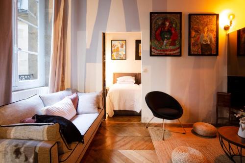 un salon avec un canapé et un lit dans l'établissement High Stay Saint Germain de Pres Paris 6, à Paris