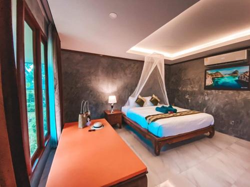 a bedroom with a bed and a table in a room at The mantra resort in Ban Tha Rua