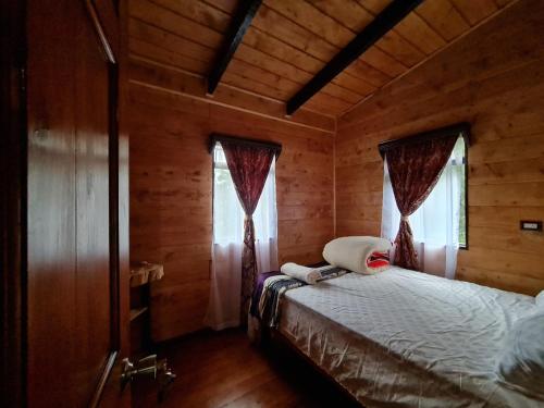a bedroom with a bed in a wooden cabin at Las Bromelias Lodge in Paso Macho