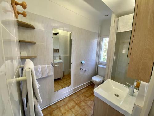 a white bathroom with a sink and a toilet at Logis Hôtel La Bellaudière in Grasse