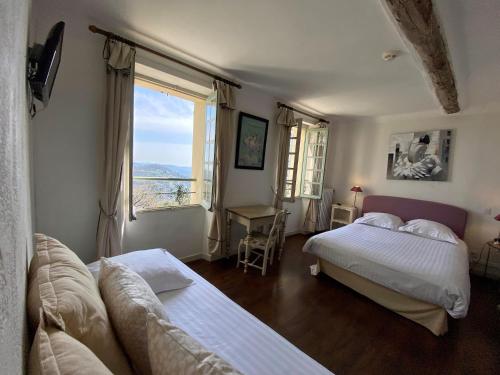 a bedroom with two beds and a couch and a window at Logis Hôtel La Bellaudière in Grasse