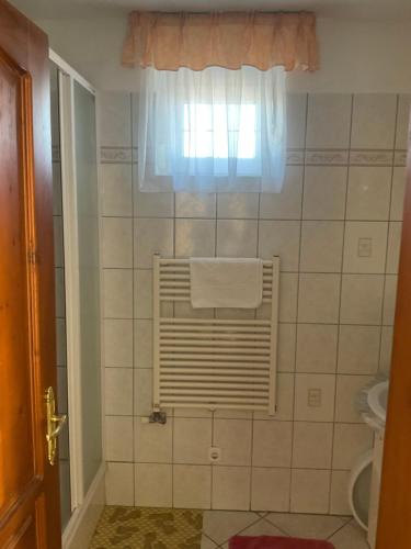 łazienka z oknem i ręcznikiem w obiekcie Arany Apartmanház Zalagyöngye w Zalakaros