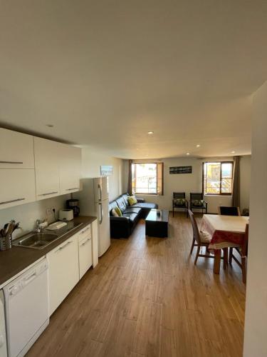 Cassis Loc - Appartement meublé في كاسيس: مطبخ وغرفة معيشة مع أريكة وطاولة