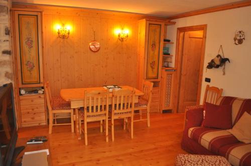 a dining room with a table and a couch at La Casa di Nicky - San Vito di Cadore in San Vito di Cadore