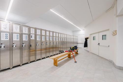 a locker room with lockers and a wooden bench at Hotel Ramon in Campitello di Fassa