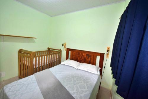 een slaapkamer met een bed en een blauw gordijn bij Casa de Praia in Coroa Vermelha