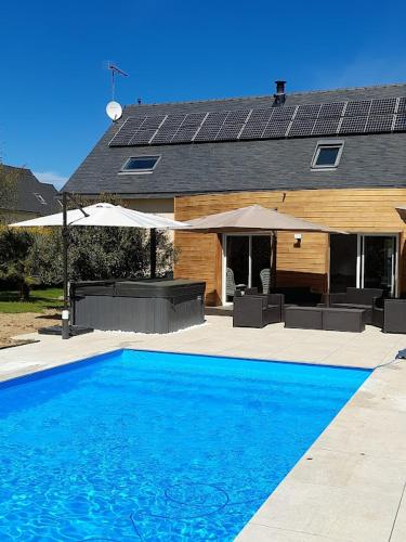 une piscine bleue devant une maison dans l'établissement chambre d'hôtes Les Hortensias, à Saint-Jean-la-Poterie
