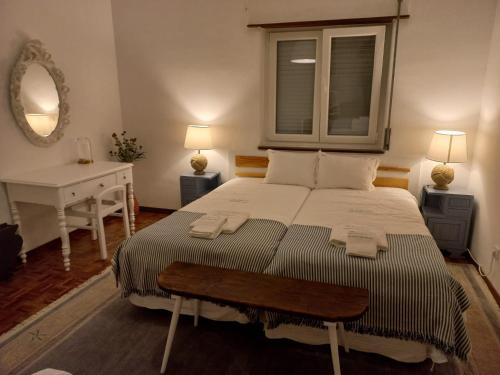 a bedroom with a bed with a desk and a window at Cardume House by Hi Alentejo in Sines