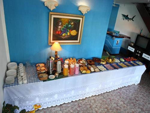 a room with a blue wall with a table of food at Pousada Azul do Mar in Arraial do Cabo