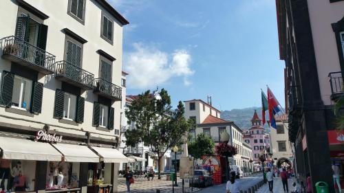 uma rua da cidade com edifícios e pessoas andando por uma rua em Edificio Charles 101 no Funchal