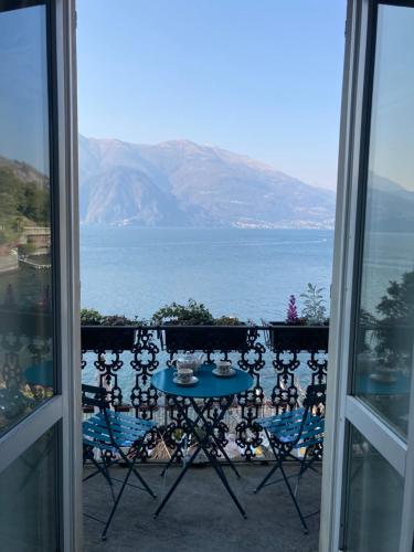 a table and chairs on a balcony with a view of the ocean at Divina Vita Apartments in Varenna