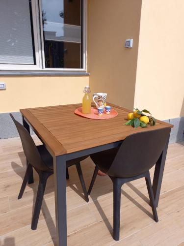 a wooden table with two chairs and a glass of orange juice at Bamboo in Procida