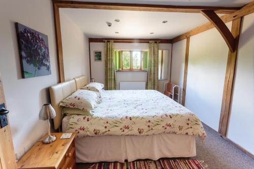 um quarto com uma cama grande e uma mesa em The Oak Lodge, Clematis Cottages, Stamford em Stamford