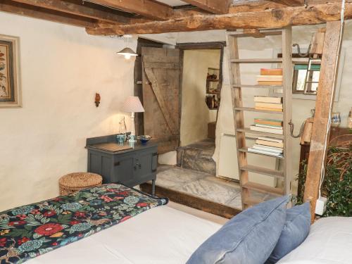 a bedroom with a bed and a desk and a ladder at The Byre in Bideford