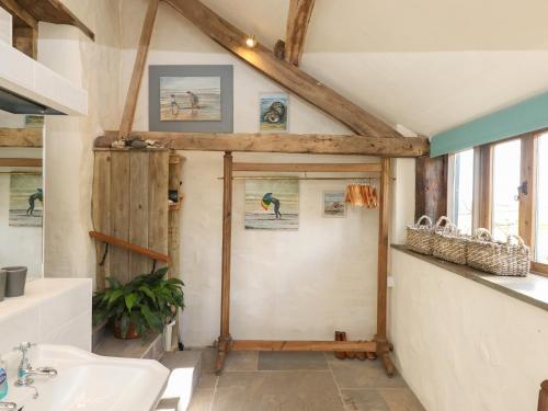 ein Badezimmer mit einer weißen Badewanne und einem Waschbecken in der Unterkunft The Byre in Bideford
