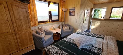 a small room with a bed and chairs and a table at Bungalow "Achtern" in Zingst