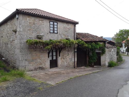 an old stone house on the side of a road at Casa de Campos in Silleda