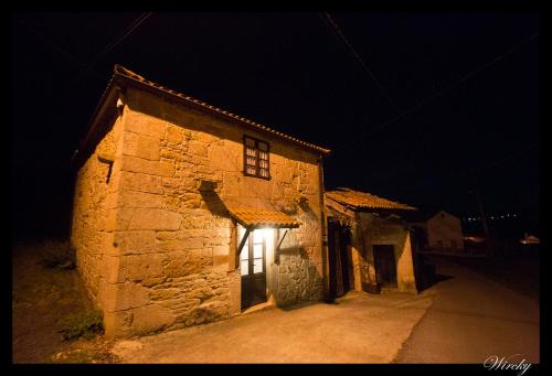 an old stone building with a light on it at night at Casa de Campos in Silleda