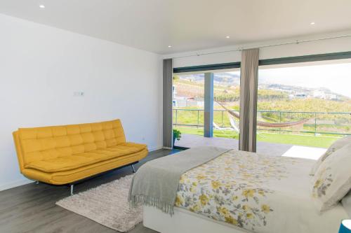 Estreito da Calheta的住宿－Stunning 1-Bed House in Estreito da Calheta，一间卧室配有黄色的床和黄色的沙发