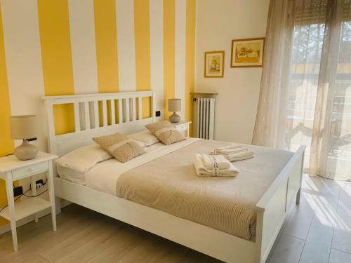 ヴェローナにあるGrazia Luxury Homeのベッドルーム1室(黄色と白のストライプの大型ベッド1台付)