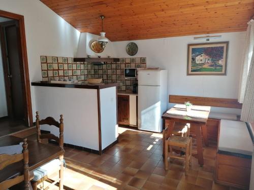uma cozinha com um frigorífico branco e uma mesa em La Casa Xica em Perafita
