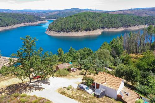 - une vue aérienne sur une maison et un lac dans l'établissement Rosa the Cosy Cabin - Gypsy Wagon - Shepherds Hut, RIVER VIEWS Off-grid eco living, à Pedrógão Grande