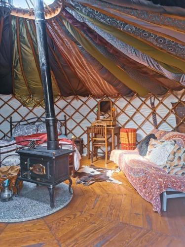 a room with a stove and a bed in a yurt at Star Gazing Luxury Yurt above beautiful RIVER, off grid in Vale do Barco