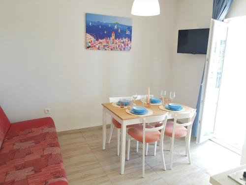 a dining room with a table with chairs and a tv at Apartman Nina in Gradac