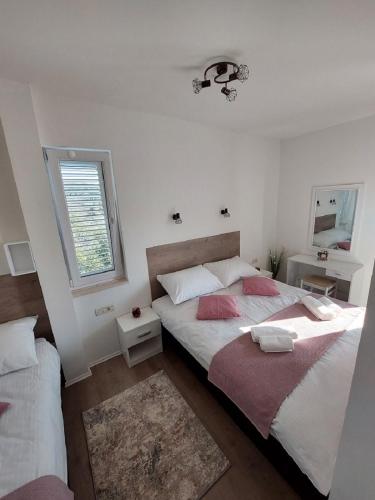 a bedroom with two beds and a window at Apartmani NIKA in Dubrovnik