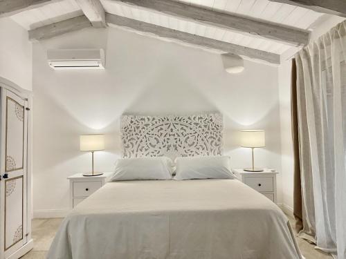 奧爾比亞的住宿－Sea Love，白色卧室配有带两盏灯的白色床